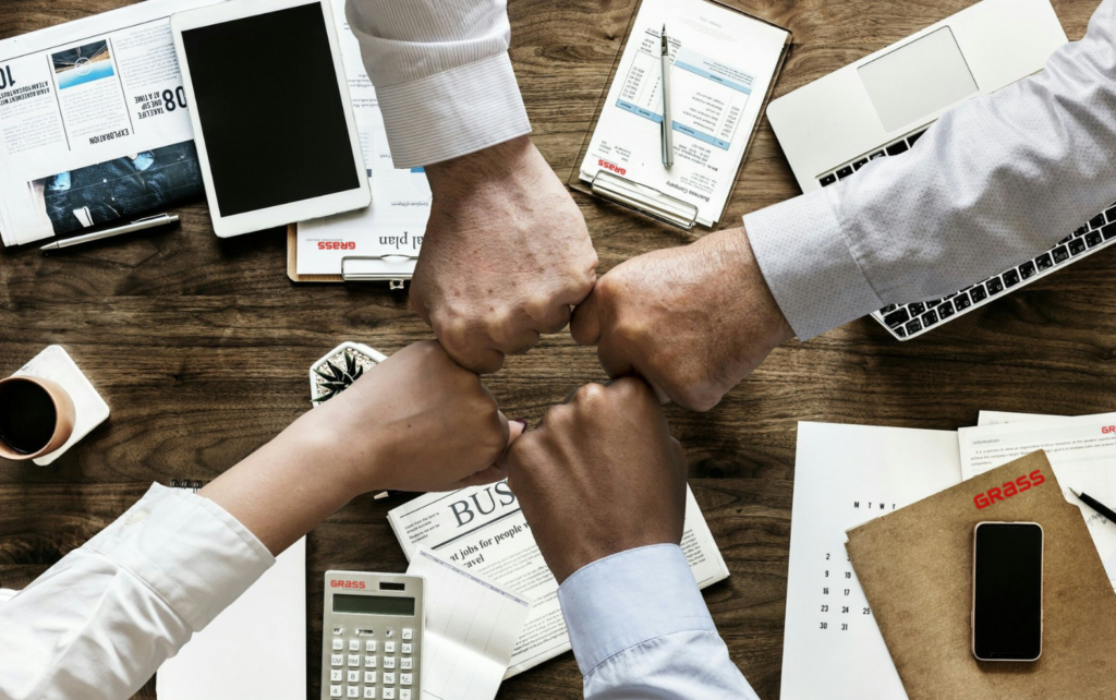 Fäuste treffen sich über eine Arbeitstisch -Teamwork